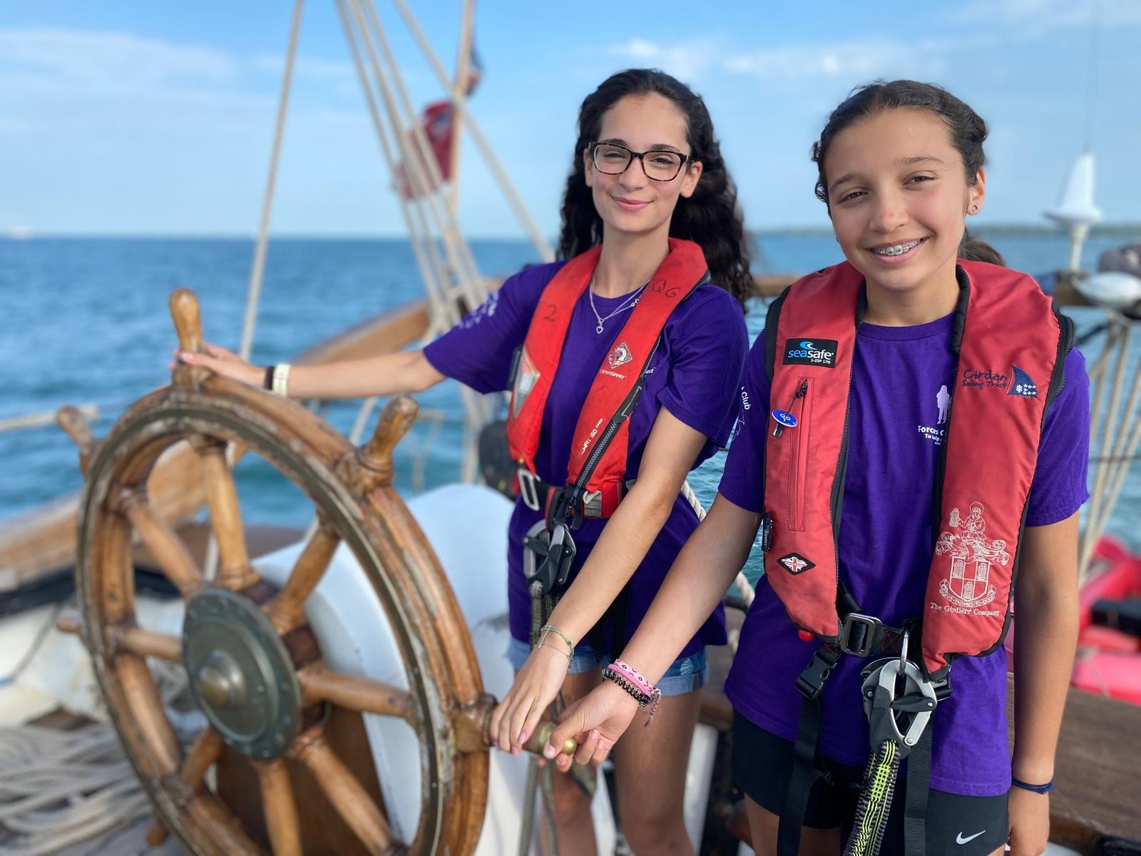 Two girls smiling and standing at the helm of Queen Galadriel