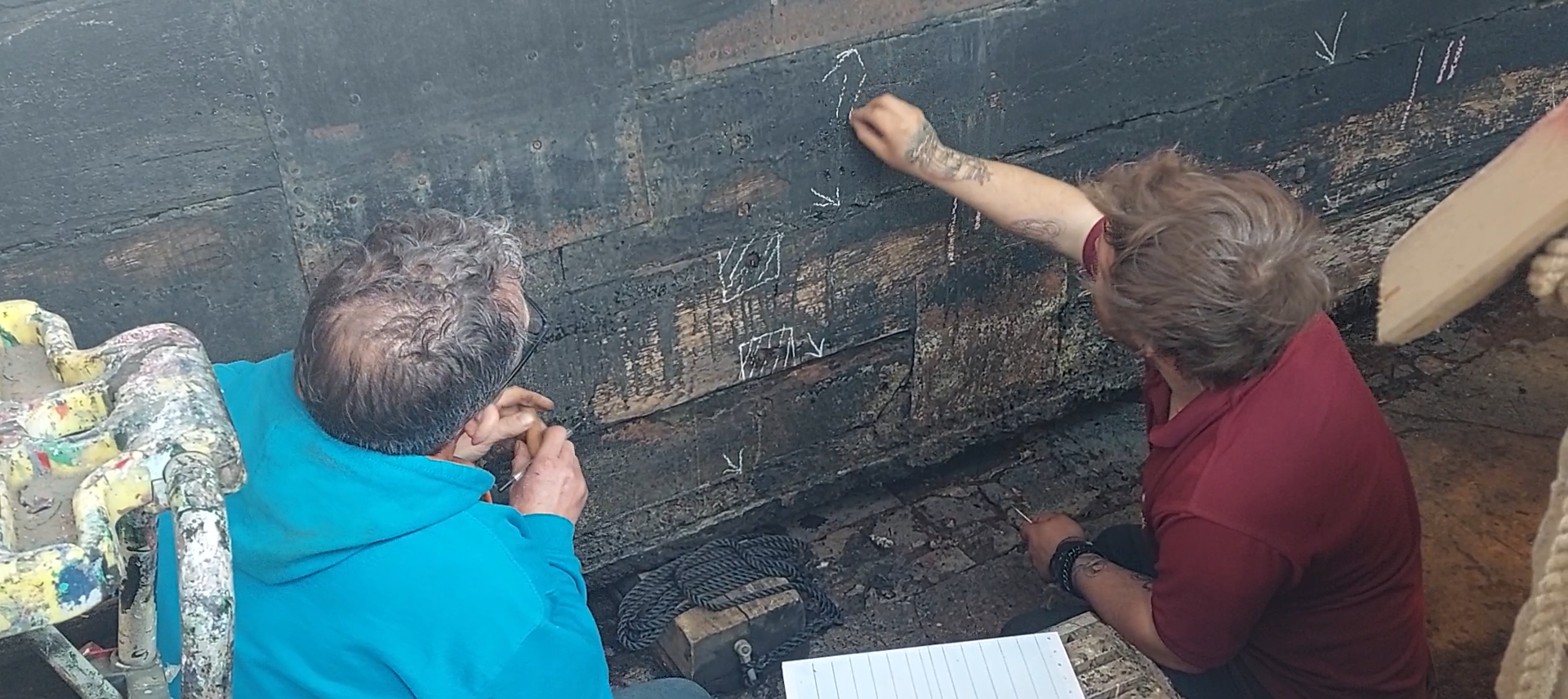 Two people surveying Hardy's hull